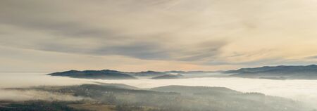 Fog in mountains before sunrise, mountain valley with clouds. View to mountains of the Carpathians.