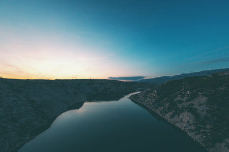 Sea bay at sunset. The river flows into the sea. Sunset on the coast. Calm water. Setting sun.